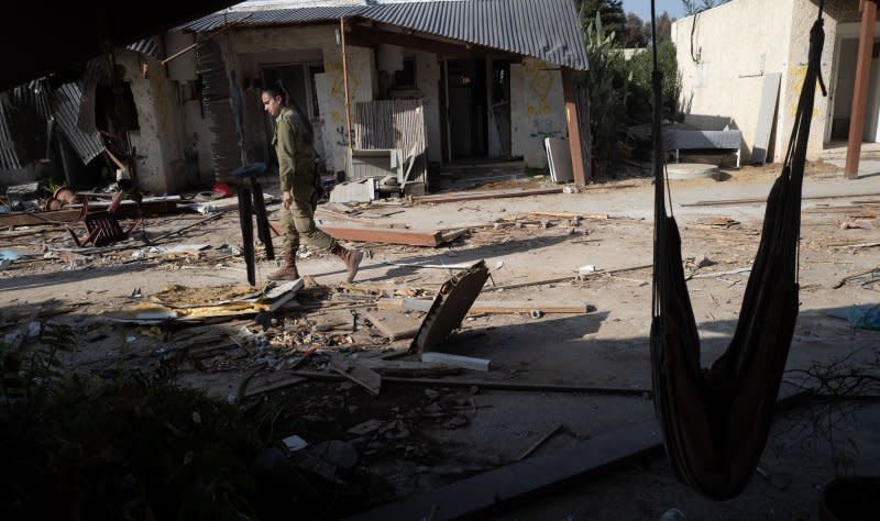 An Israeli soldier passes destruction in the community of Kfar Azza on Sunday, November 5, 2023. This community is close to the border with the Gaza Strip and on October 7, 2023 the Hamas terrorists infiltrated here and killed some 59 Israelis. Photo by Jim Hollander/UPI
