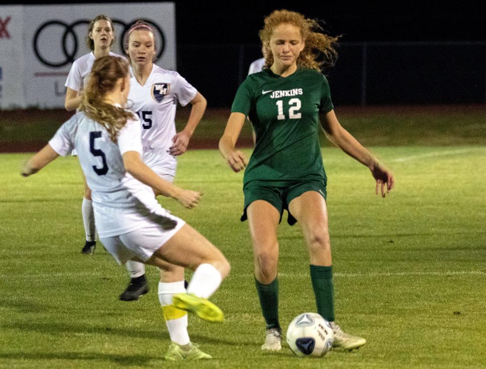 George Jenkins' Georgiana Strawbridge (12) makes a run up the field as Winter Haven's Hannah Roop attempts to clear the ball on Tuesday night in the championship match of the Class 6A, District 6 girls soccer tournament.