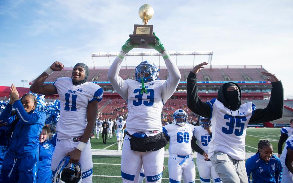 Members of the Salem High School football team celebrate with their trophy after Salem defeated Woodbury, 34-8, in the South-Central Group 1 regional championship football game played at Rutgers University in Piscataway on Sunday, December 5, 2021.