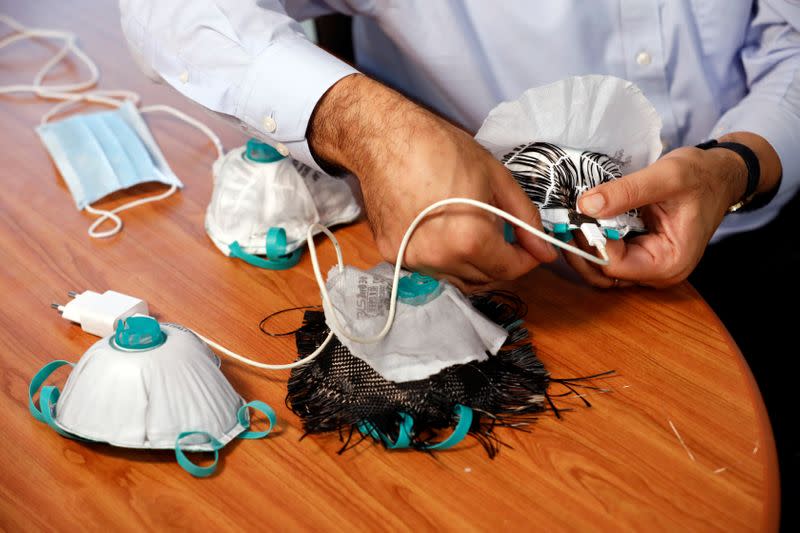 An Israeli researcher, part of a team which say they have invented a reusable face mask that can disinfect itself and kill the coronavirus disease (COVID-19), takes part in a demonstration for Reuters in Haifa, northern Israel