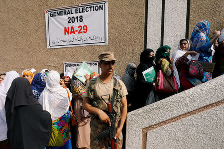 Army soldier stands guards where electoral workers gather to collect election materials at distribution point, ahead of general election in Peshawar, Pakistan July 24, 2018. REUTERS/Fayaz Aziz