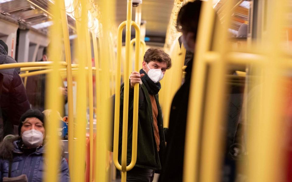 A commuter wears an FFP2 protective face mask on a public transport underground train in Vienna  -  ALEX HALADA  / AFP