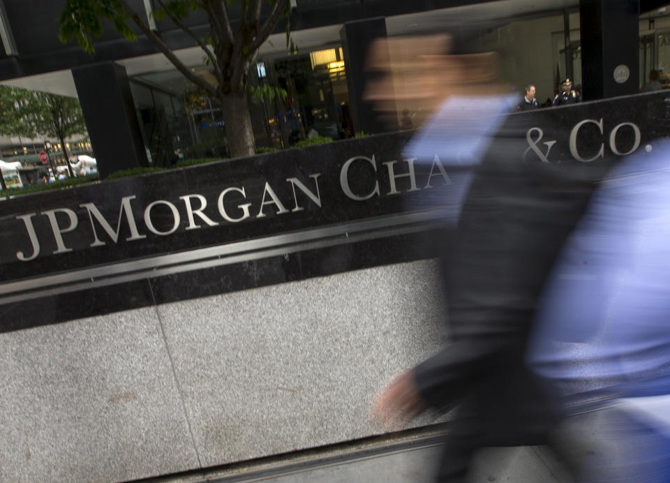 People pass the JP Morgan Chase & Co. Corporate headquarters in the Manhattan borough of New York City, May 20, 2015. A U.S. regulator has granted waivers to JPMorgan Chase & Co and four other major banks allowing them to continue their usual securities business, after they agreed to plead guilty to criminal charges, according to a person familiar with the matter. The regulator, the Securities and Exchange Commission, is expected to publicly confirm the waivers will be in place once the banks formally enter guilty pleas, and the announcement could come by the end of the day Wednesday, two other sources told Reuters. REUTERS/Mike Segar