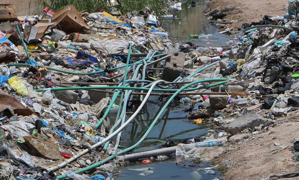 In this Saturday, July, 20, 2019 photo, potable water pipes mix with sewage at garbage dump in Basra, Iraq. A leading human rights organization has accused Iraqi authorities of failing to properly address underlying causes for an ongoing water crisis in Iraq's southern region. A report issued Monday by Human Rights Watch on the chronic water shortages and pollution in Iraq's Basra province says authorities continue to allow activities that pollute Basra's water resources despite the health risks to residents. (AP Photo/Nabil al-Jurani)