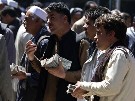 Afghan money changers offer Afghanis for sale at Kabul's largest money market April 23, 2014. REUTERS/Omar Sobhani