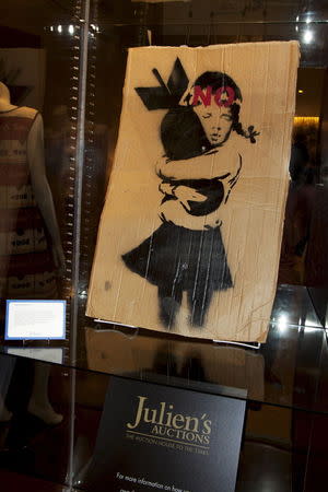 A painting entitled "Bomb Hugger" is shown on display in a hotel in Beverly Hills, California in this June 28, 2015 handout photo released to Reuters July 28, 2015. "Bomb Hugger" and a huge street mural painted on a derelict Detroit auto factory by elusive British artist Banksy is going up for auction in Beverly Hills and could fetch up to $400,000 dollars for a local non-profit group, Julien's Auctions said on Wednesday. REUTERS/Julien's Auctions/Handout via Reuters