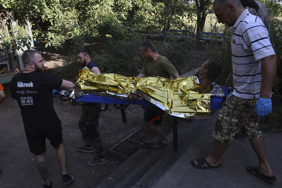 People carry an injured Ukrainian serviceman in a frontline medical stabilization point in Zaporizhzhia region, Ukraine, Thursday, July 27, 2023. (AP Photo/Kateryna Klochko)