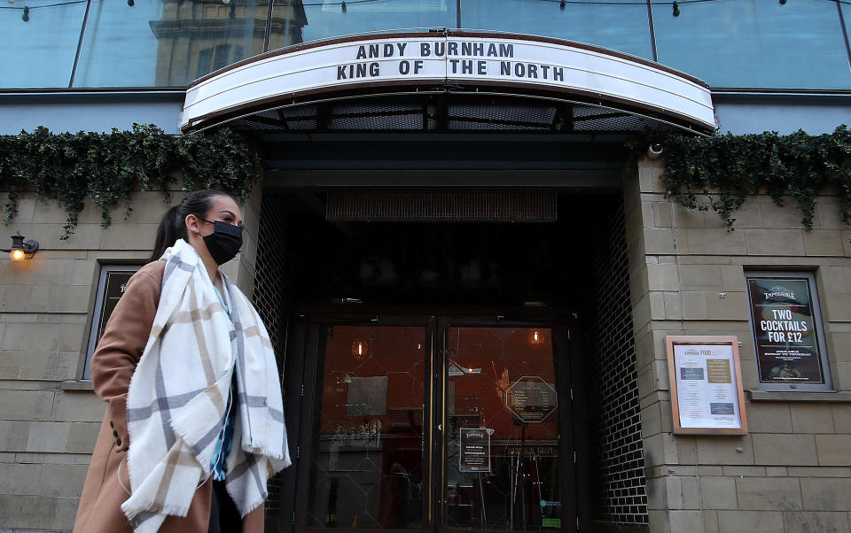 A person wearing a face mask walks past a sign on Theatre Impossible in Manchester as the Government is preparing to impose stringent new coronavirus controls on 2.8 million people after talks with the local leaders for Greater Manchester failed to reach agreement. Leaders have been given until midday on Tuesday to reach a deal, or face unilateral Government action, after 10 days of negotiations failed to reach an agreement. (Photo by Martin Rickett/PA Images via Getty Images)