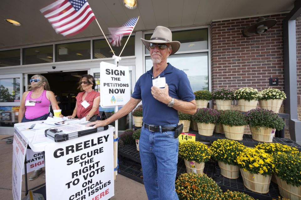 In this Friday, July 23, 2021, photograph, John G. Gauthiere, president of his own civil engineering consulting firm, collects signatures outside a grocery store in west Greeley, Colo. Figures released this month show that population growth continues unabated in the South and West, even as temperatures rise and droughts become more common. That in turn has set off a scramble of growing intensity in places like Greeley to find water for the current population, let alone those expected to arrive in coming years. (AP Photo/David Zalubowski)