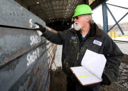 Jeff Mitchell marks information on slabs of steel after they arrive at the Novolipetsk Steel PAO steel mill in Farrell, Pennsylvania, U.S., March 9, 2018. REUTERS/Aaron Josefczyk