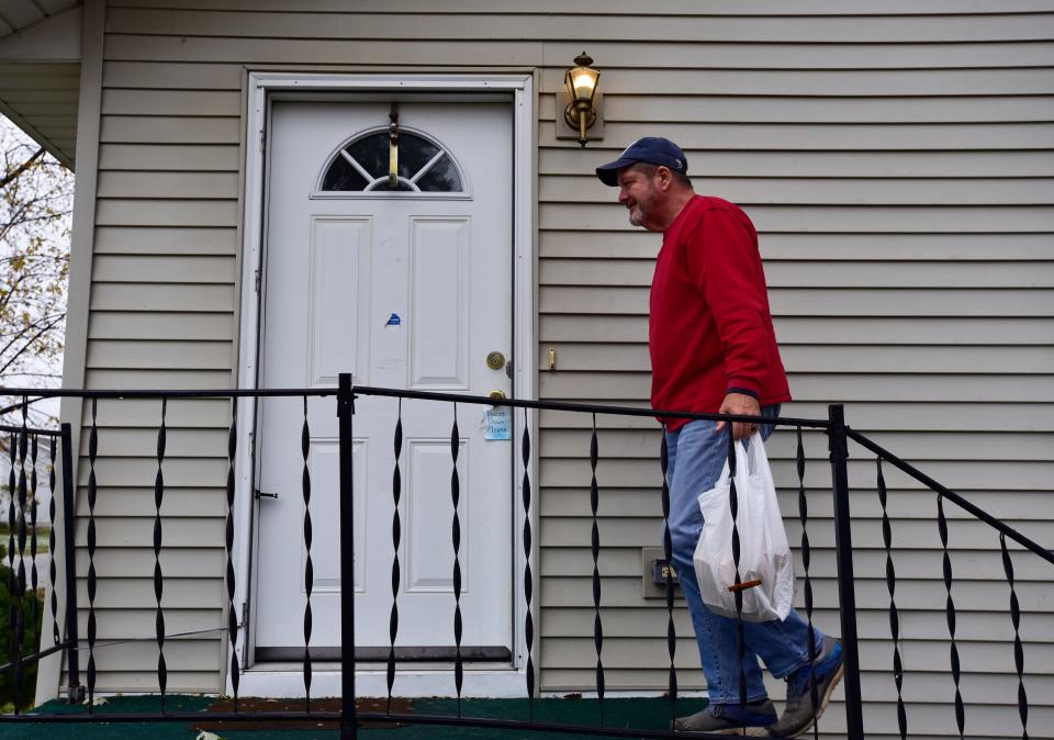 Dan Shelton walks up the porch to deliver a pre-made meal to a client on Wednesday, Nov. 16, 2022.