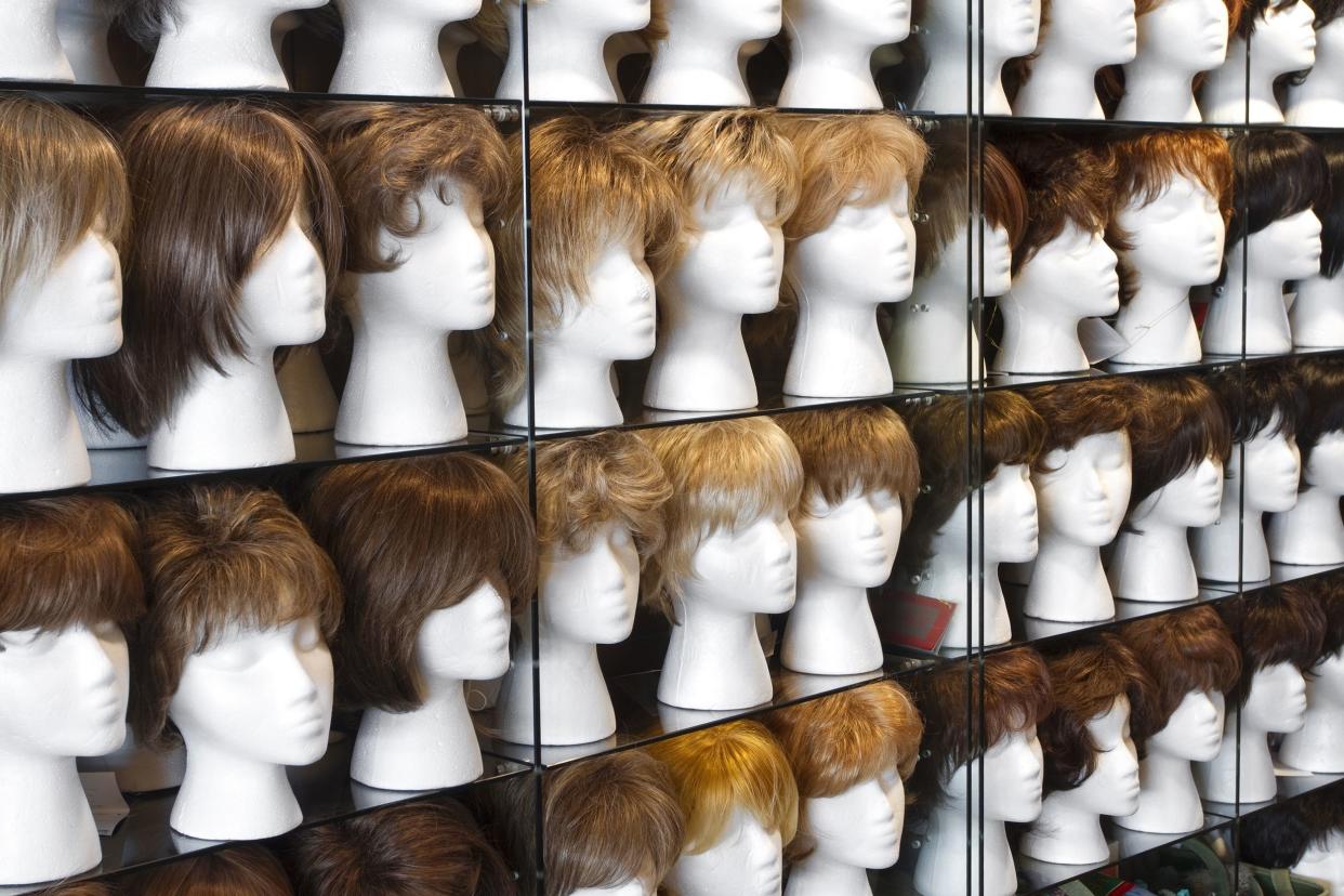 wall of differently colored wigs