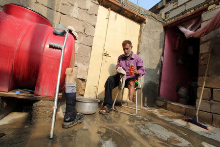 A man disabled by a landmine explosion cleans and disinfects his truncated leg in the village of Bitr, which in Arabic means "amputation", in Al-Tanouma district, east of Basra, Iraq February 25, 2018. REUTERS/Essam Al-Sudani/Files