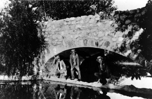 These men are standing under a bridge at Memorial Park. In the 1920s, the park still had a lake.