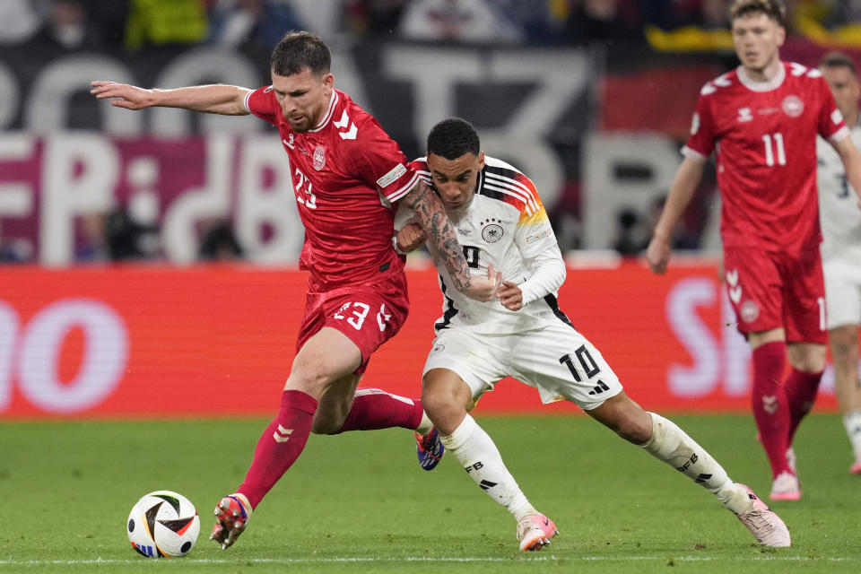 El alemán Jamal Musiala pelea por el balón con el danés Pierre-Emile Hojbjerg en el encuentro de los octavos de final de la Eurocopa el sábado 29 de junio del 2024. (AP Foto/Andreea Alexandru)