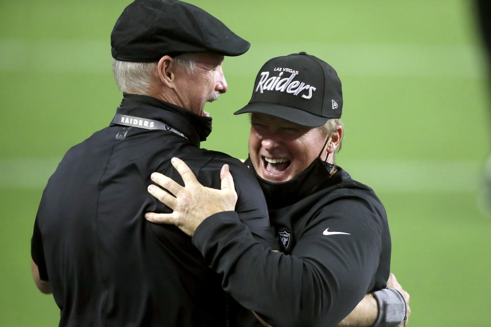 Las Vegas Raiders GM Mike Mayock, left, embraces head coach Jon Gruden after defeating the New Orleans Saints in an NFL football game, Monday, Sept. 21, 2020, in Las Vegas. (AP Photo/Isaac Brekken)