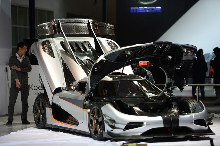 This picture taken on April 19, 2014 shows a Mazda car being installed in an exhibition hall ahead of the Beijing International Automotive Exhibition