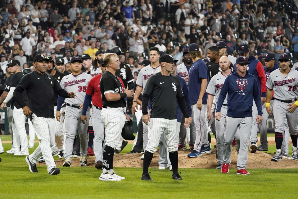 Players mill on the field after Chicago White Sox's Andrew Vaughn (25) was hit by pitch from Minnesota Twins reliever Jorge Lopez during the ninth inning of a baseball game in Chicago, Friday, Sept. 2, 2022. The White Sox won 4-3. (AP Photo/Nam Y. Huh)