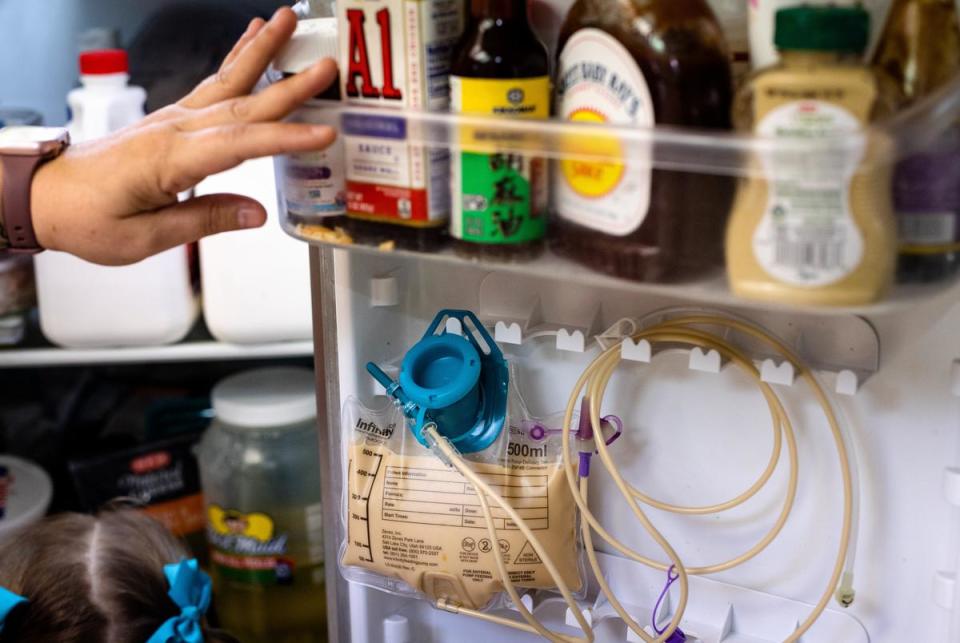 Jodi Whites shows the gastrostomy tube that her daughter Amelia uses to eat, in it's storage space in their fridge at their home in New Braunfels, on July 27, 2023.