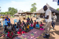 A staff member from the Mines Advisory Group (MAG) teaches children about the risks of unexploded mines, in Moli village, Eastern Equatoria state, in South Sudan Friday, May 12, 2023. As South Sudanese trickle back into the country after a peace deal was signed in 2018 to end a five-year civil war, many are returning to areas riddled with mines left from decades of conflict. (AP Photo/Sam Mednick)