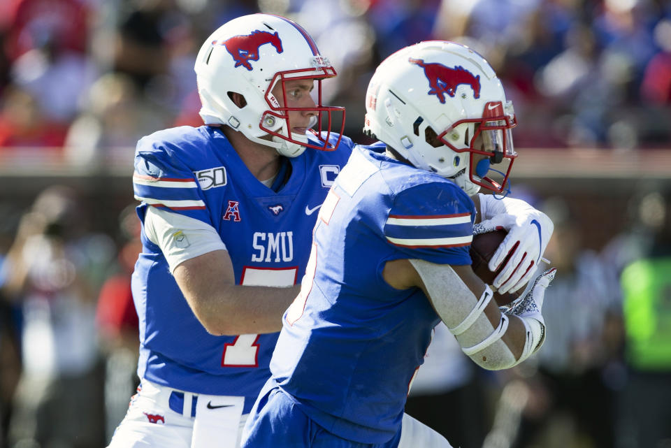 SMU quarterback Shane Buechele (7) hands the ball off to running back Xavier Jones (5) during the second quarter of an NCAA college football game against Temple in Dallas, Saturday, Oct. 19, 2019. (AP Photo/Sam Hodde)