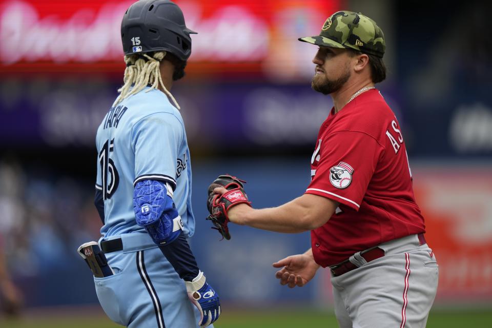 Cincinnati Reds pitcher Graham Ashcraft, right, tags out Toronto Blue Jays' Raimel Tapia (15) during fourth-inning baseball game action in Toronto, Sunday, May 22, 2022. (Frank Gunn/The Canadian Press via AP)