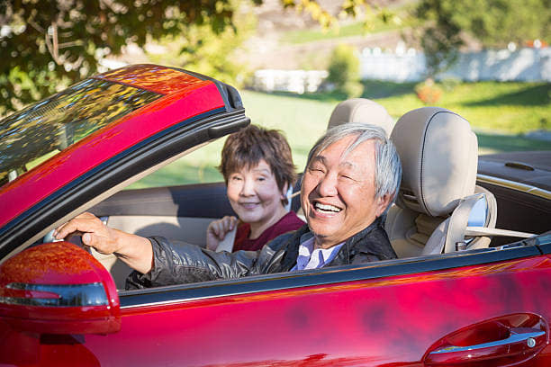 elderly couple driving car