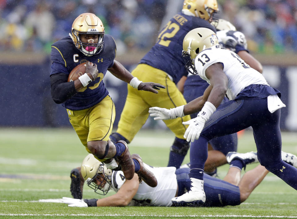 Notre Dame running back Josh Adams (33) goes around Navy safety Juan Hailey (13) during the first half of an NCAA college football game in South Bend, Ind., Saturday, Nov. 18, 2017. (AP Photo/Michael Conroy)