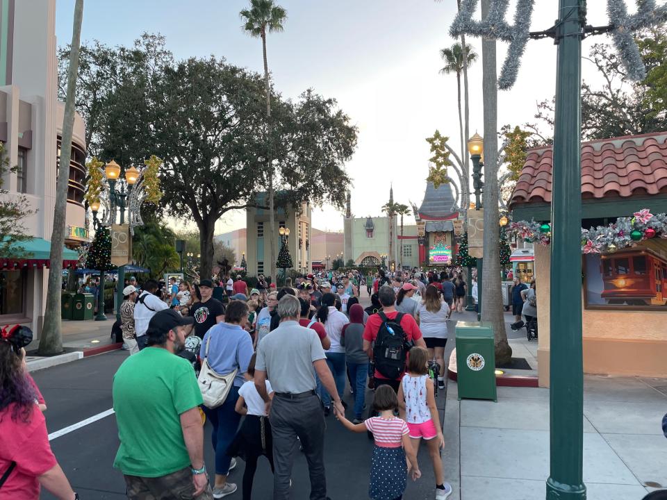 people walking down the main entrance path at hollywood studios in disney world