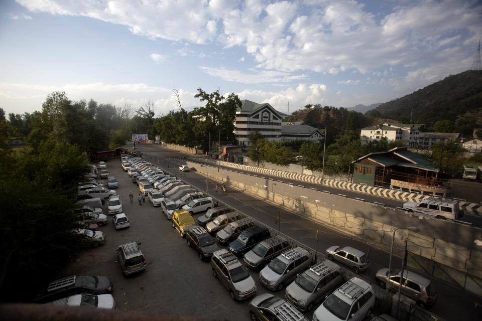 Kashmiri taxi drivers walk near their parked vehicles inside a deserted tourist taxi stand during lockdown to stop the spread of the coronavirus in Srinagar, Indian controlled Kashmir, July 20, 2020. Indian-controlled Kashmir's economy is yet to recover from a colossal loss a year after New Delhi scrapped the disputed region's autonomous status and divided it into two federally governed territories. (AP Photo/Mukhtar Khan)