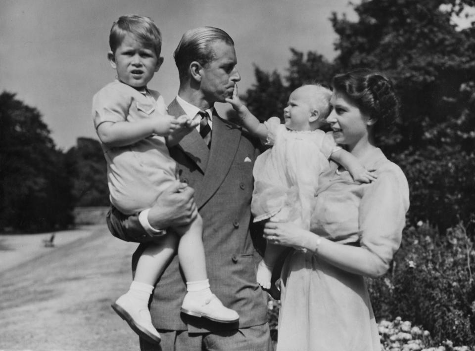 FILE - In this Aug. 1951 file photo, Britain's Queen Elizabeth II, then Princess Elizabeth, stands with her husband Prince Philip, the Duke of Edinburgh, and their children Prince Charles and Princess Anne at Clarence House, the royal couple's London residence. Prince Philip was born into the Greek royal family but spent almost all of his life as a pillar of the British one. His path was forged when he married the heir to the British throne, and a promising naval career was cut short when his wife suddenly became Queen Elizabeth II. Nevertheless, he set about forging a place for himself as royal consort. He was a patron of charities and a supporter of projects for young people. He was married for more than 73 years and was still carrying out royal engagements into his late 90s. (AP Photo/Eddie Worth, File)