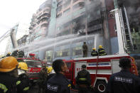 Firefighters attempt to put out fire at a market building during a fire at China town Thursday, Feb. 20, 2020, in Yangon, Myanmar. Firefighters contained a blaze in the 12-story building in the country's biggest city. (AP Photo/Thein Zaw)