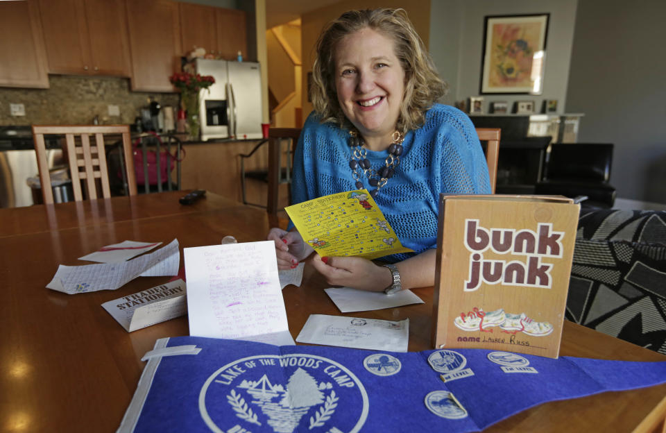 This May 15, 2013 photo shows Lauren Russ in Chicago, posing with letters that she wrote home as a child from sleepaway camp begging her parents to come and get her. While many children enjoy attending overnight camp, Russ is one of a number of adults who look back on the experience with less-than-fond memories of feeling homesick and lonely. Russ' tearful letters home to mom and dad are so famous in her family that her parents even read them at her wedding shower 10 years ago. (AP Photo/Michael S. Green)