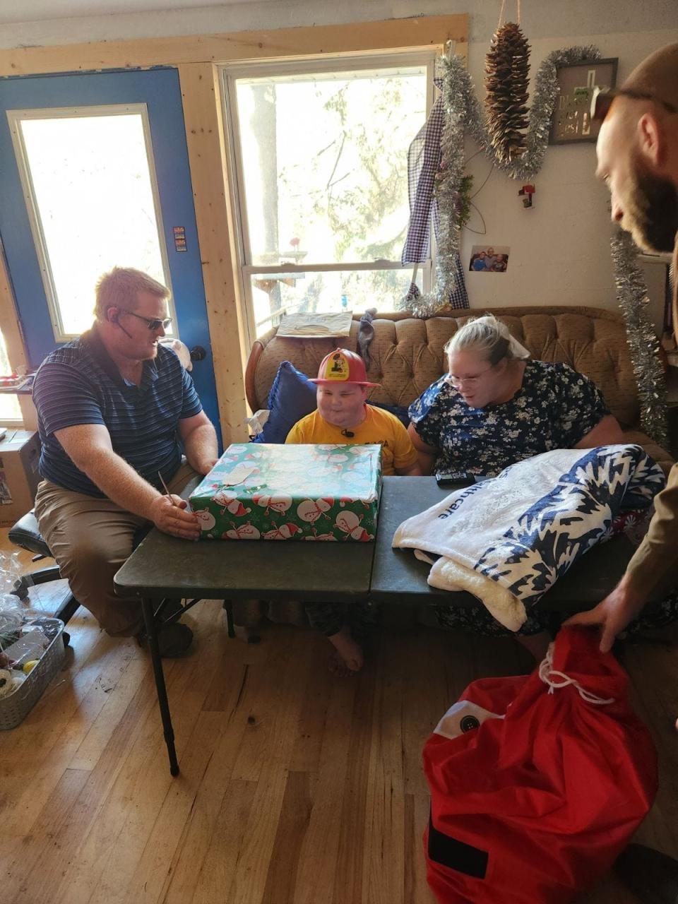 Andrew Miller of Conesville is shown with his father, Roman, and his mother, Linda, as he opens presents from his many well-wishers on Dec. 12, his 9th birthday.