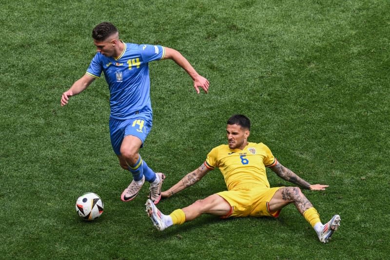 Ukraine's Heorhij Sudakow (L) and Romania's Marius Mihai Marin battle for the ball during the UEFA Euro 2024 group E soccer match between Romania and Ukraine at the Munich Football Arena. Sven Hoppe/dpa