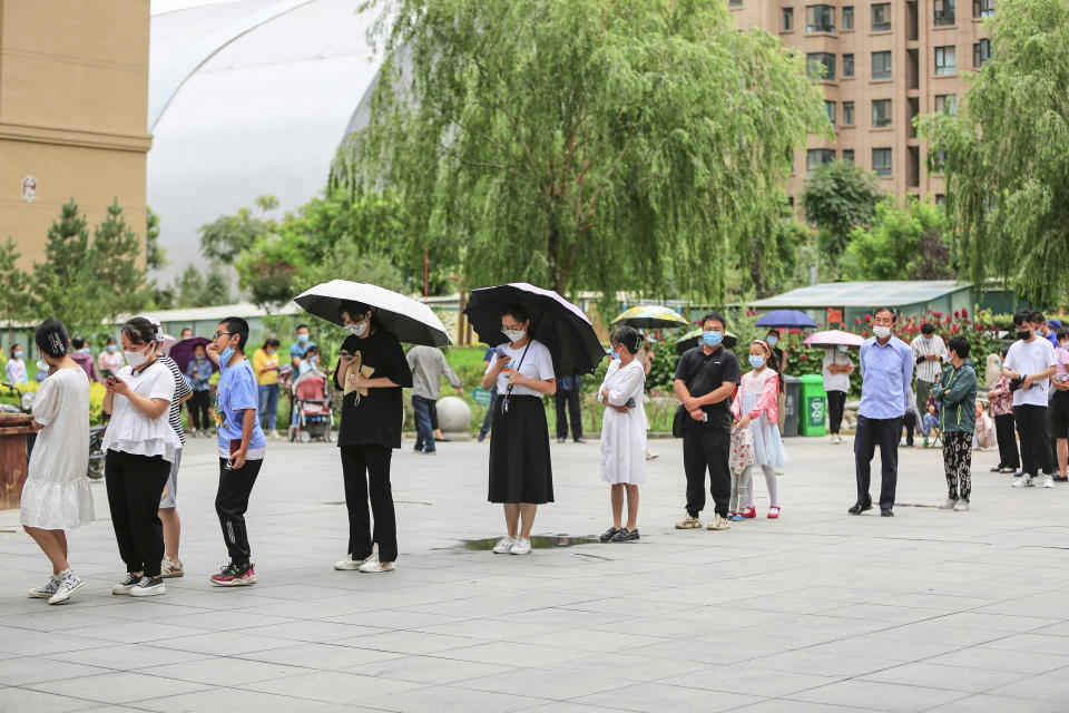 This photo taken on July 13, 2022 shows people queueing to undergo nucleic acid tests for the Covid-19 coronavirus at a residental area in Zhangye in China's northwestern Gansu province. - China OUT (Photo by AFP) / China OUT (Photo by STR/AFP via Getty Images)