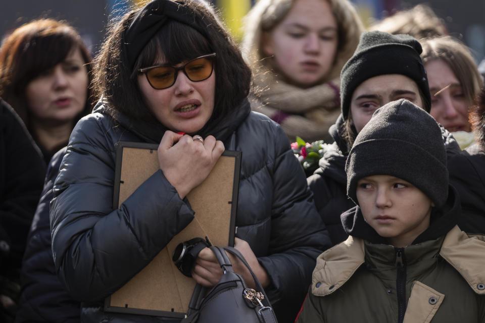 Mother Tetiana and brother Vlad mourn during the funeral of 20 year-old soldier Vladyslav Belechynskyi, at Lviv cemetery, on Wednesday, Feb. 22, 2023. Belechynskyi died near Bakhmut, on Feb.16. (AP Photo/Petros Giannakouris)