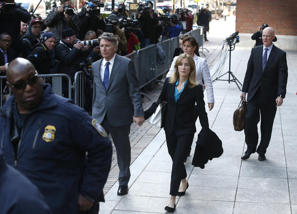 Felicity Huffman, in blue shirt at center, leaves the John Joseph Moakley United States Courthouse in Boston on April 3, 2019.&nbsp; (Photo: Boston Globe via Getty Images)
