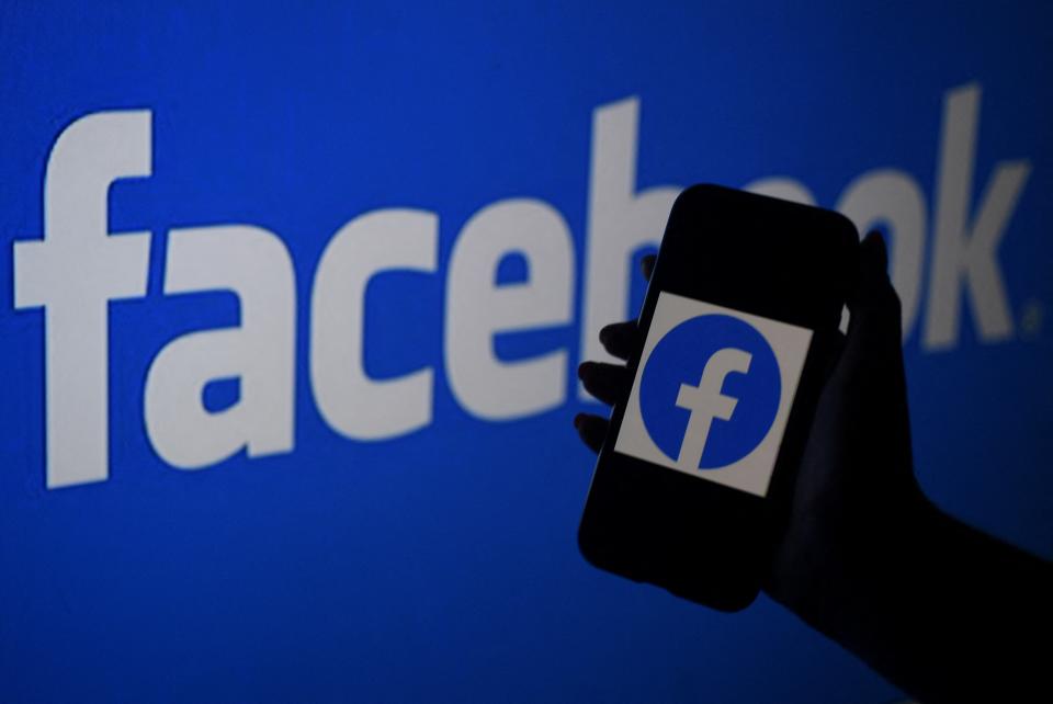 Smartphone screen displaying Facebook logo on a Facebook website background (AFP via Getty Images)