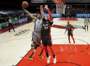 San Antonio Spurs forward Keldon Johnson, left, drives to the basket on Portland Trail Blazers center Jusuf Nurkic during the first half of an NBA basketball game in Portland, Ore., Saturday, May 8, 2021. (AP Photo/Steve Dykes)