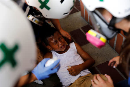 Volunteers members of primary care response team help a child during a rally against President Nicolas Maduro in Caracas, Venezuela May 24, 2017. REUTERS/Carlos Garcia Rawlins