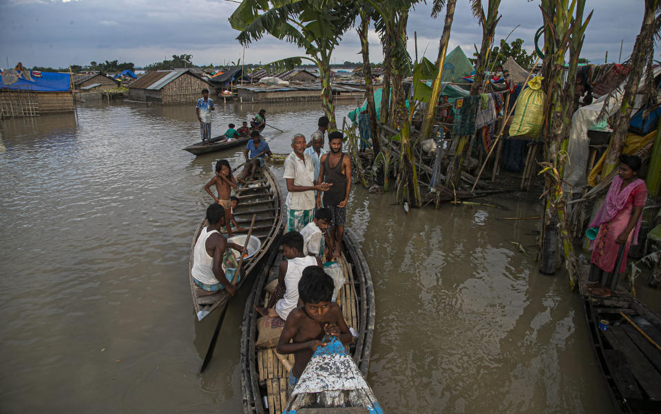 Indian flood affected people take shelter on boats near their submerged houses along river Brahmaputra in Morigaon district, Assam, India, Thursday, July 16, 2020. Floods and landslides triggered by heavy monsoon rains have killed dozens of people in this northeastern region. (AP Photo/Anupam Nath)