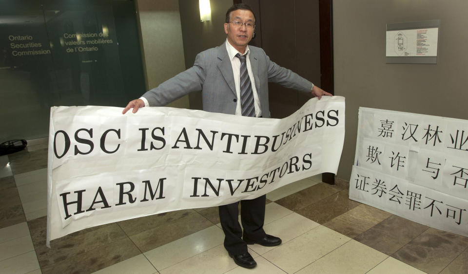Weizhen Tang, founder of the Weizhen Tang Corp. investment firm and alleged Ponzi scheme operator, stands for a photograph while protesting outside of the Ontario Securities Commission (OSC) hearing rooms in Toronto, Ontario, Canada, on Thursday, Sept. 8, 2011. Canada's main securities regulator extended until Jan. 25 the cease-trade on the shares of Sino-Forest Corp., the Chinese forestry company it said may have committed fraud. Photographer: Norm Betts/Bloomberg via Getty Images 