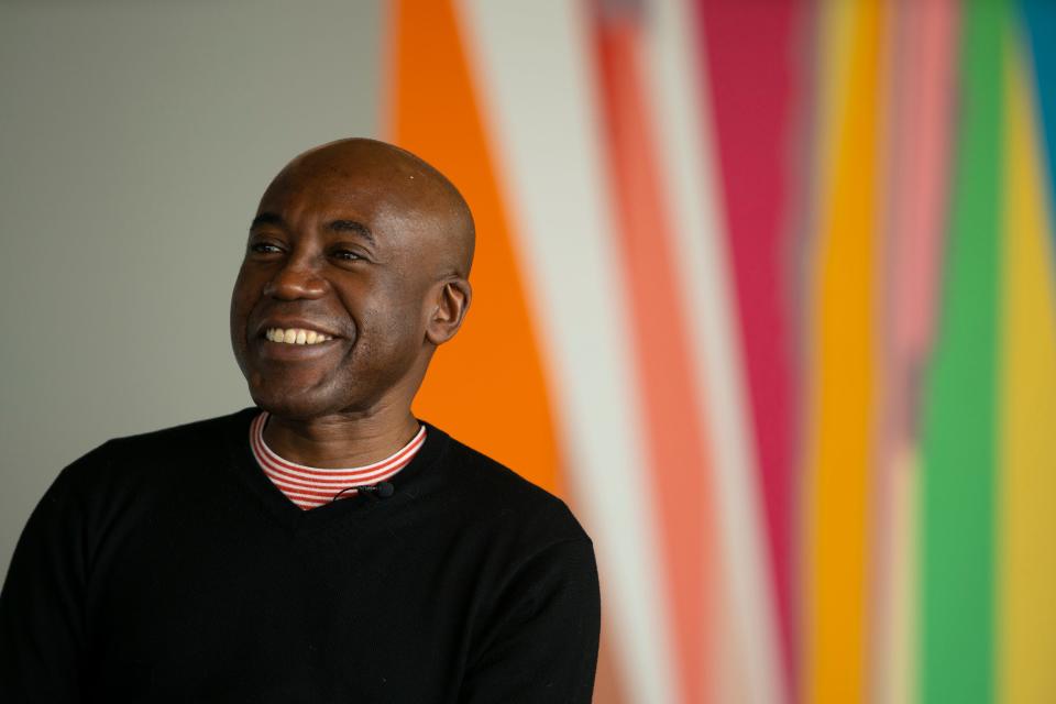 Odili Donald Odita speaks to reporters in front of his in progress mural at the Stanley Museum of Art Tuesday, April 12, 2022.