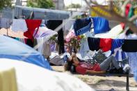 An asylum-seeking migrant, who was apprehended and returned to Mexico under Title 42 after crossing the border from Mexico into the U.S., rests in a public square where hundreds of migrants live in tents, in Reynosa