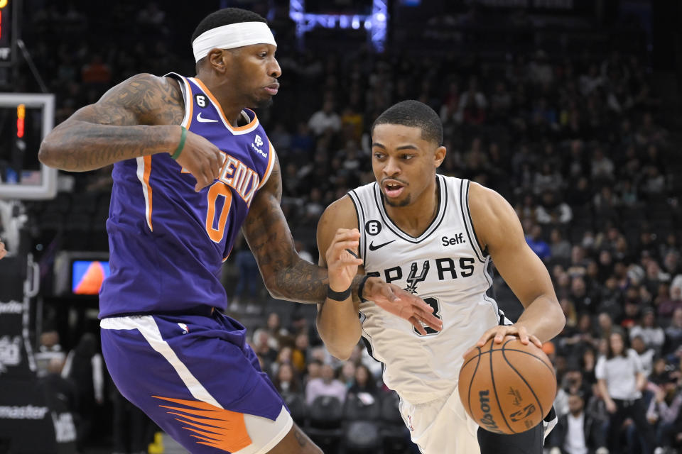 San Antonio Spurs' Keldon Johnson, right, drives against Phoenix Suns' Torrey Craig during the first half of an NBA basketball game, Saturday, Jan. 28, 2023, in San Antonio. (AP Photo/Darren Abate)