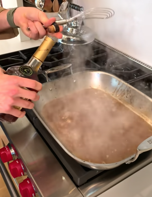 Someone pouring wine into a dish.