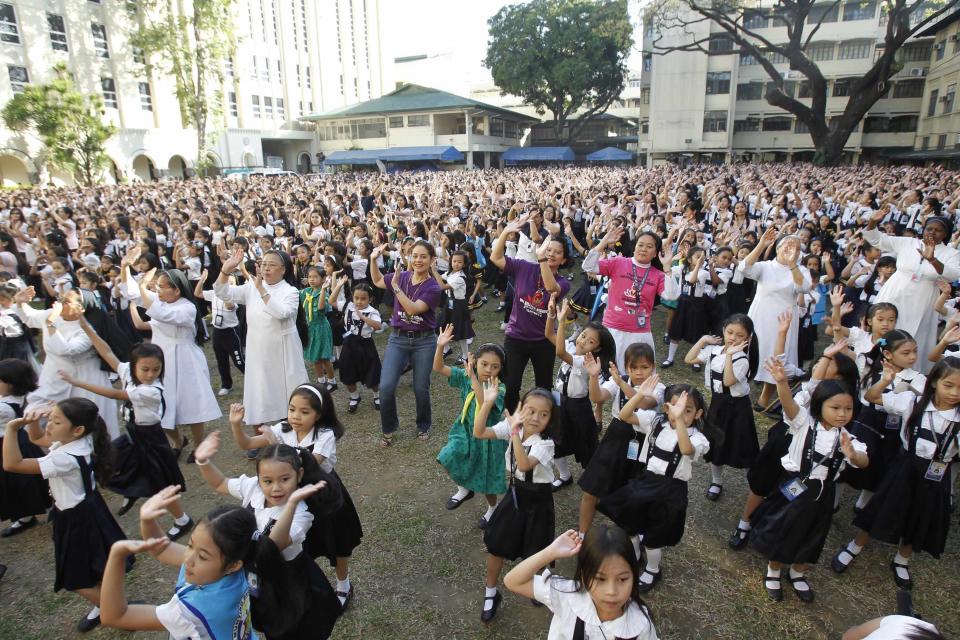 Thousands of students, faculty members and Roman Catholic nuns dance to the theme song of the One Billion Rising campaign in the quadrangle of the St. Scholastica college in Manila February 14, 2013. One Billion Rising is a global campaign to call for an end to violence against women and girls, according to its organisers. REUTERS/Romeo Ranoco (PHILIPPINES - Tags: POLITICS SOCIETY EDUCATION RELIGION)