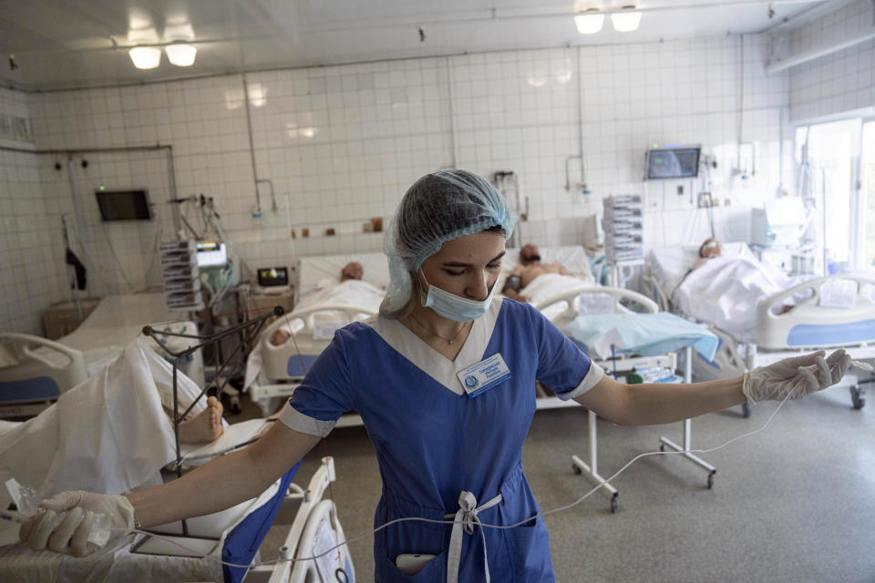 A nurse prepares to treat Ukrainian servicemen at the ICU of Mechnikov Hospital in Dnipro, Ukraine, Saturday, July 15, 2023. A surge of wounded soldiers has coincided with the major counteroffensive Ukraine launched last month to try to recapture its land from Russian forces. Surgeons at Mechnikov Hospital, one of the country's biggest, are busier now than perhaps at any other time since Russia began its invasion 17 months ago. (AP Photo/Evgeniy Maloletka)