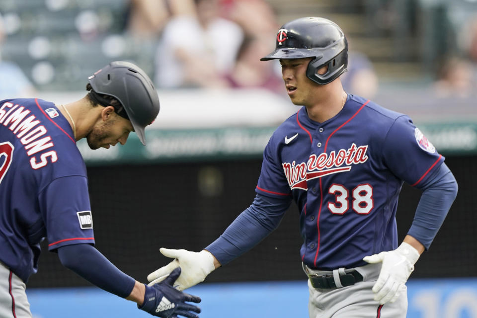 Minnesota Twins' Rob Refsnyder (38) is congratulated by Andrelton Simmons after hitting a solo home run in the third inning of a baseball game against the Cleveland Indians, Friday, May 21, 2021, in Cleveland. (AP Photo/Tony Dejak)